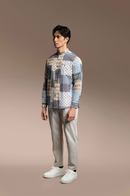 Man wearing a Onésimus Men's Casual Shirts: Geometric Prints and light pants on a beige background