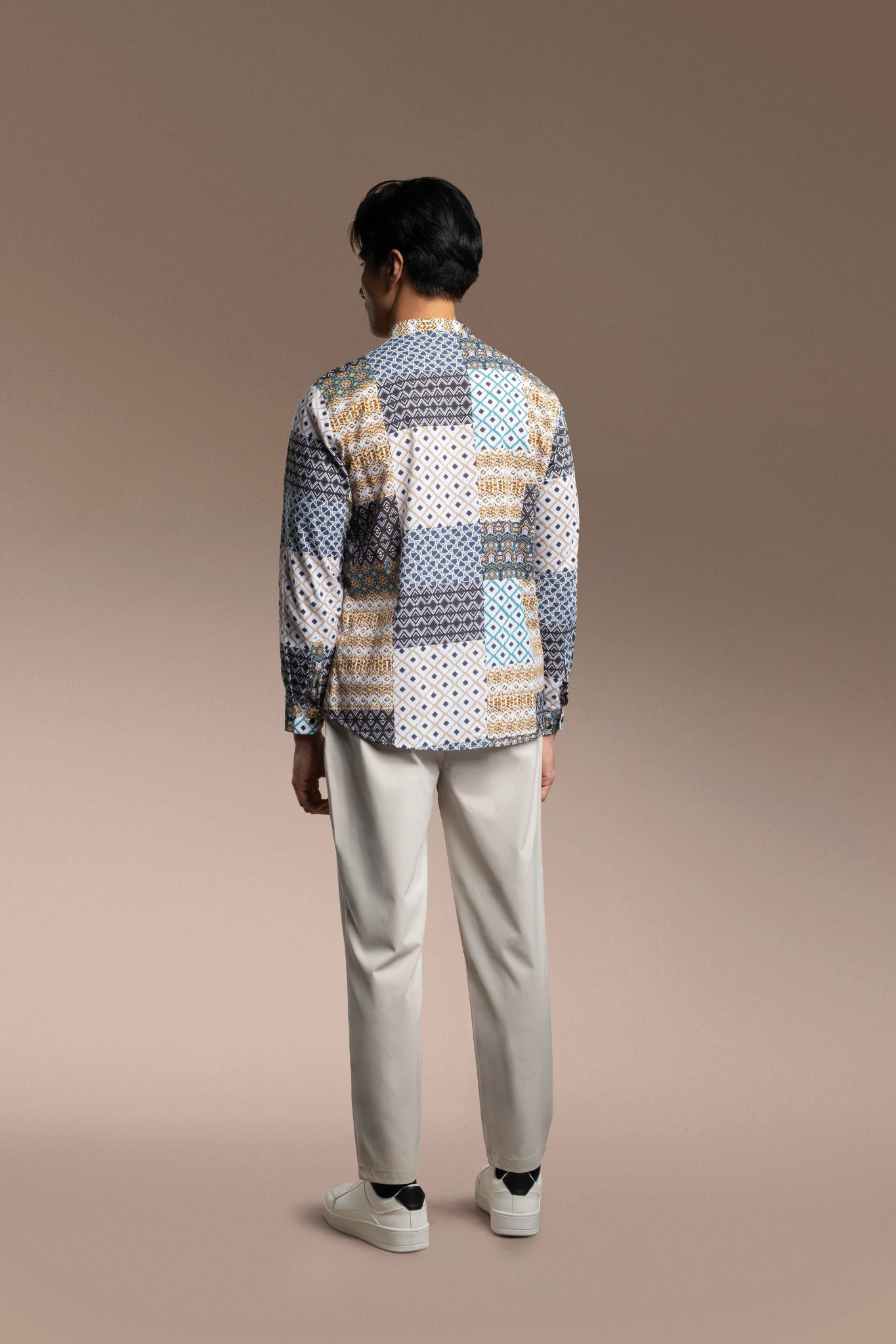 Person wearing a patterned Onésimus Men's Casual Shirts: Geometric Prints and beige pants on a beige background