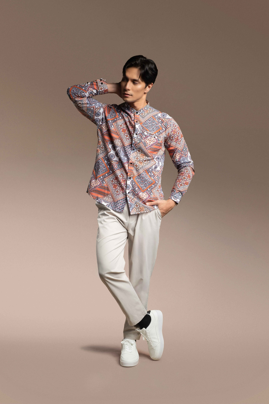 A man modeling a Onésimus Men's Casual Shirts in Pure Cotton, set against a solid warm brown studio background.