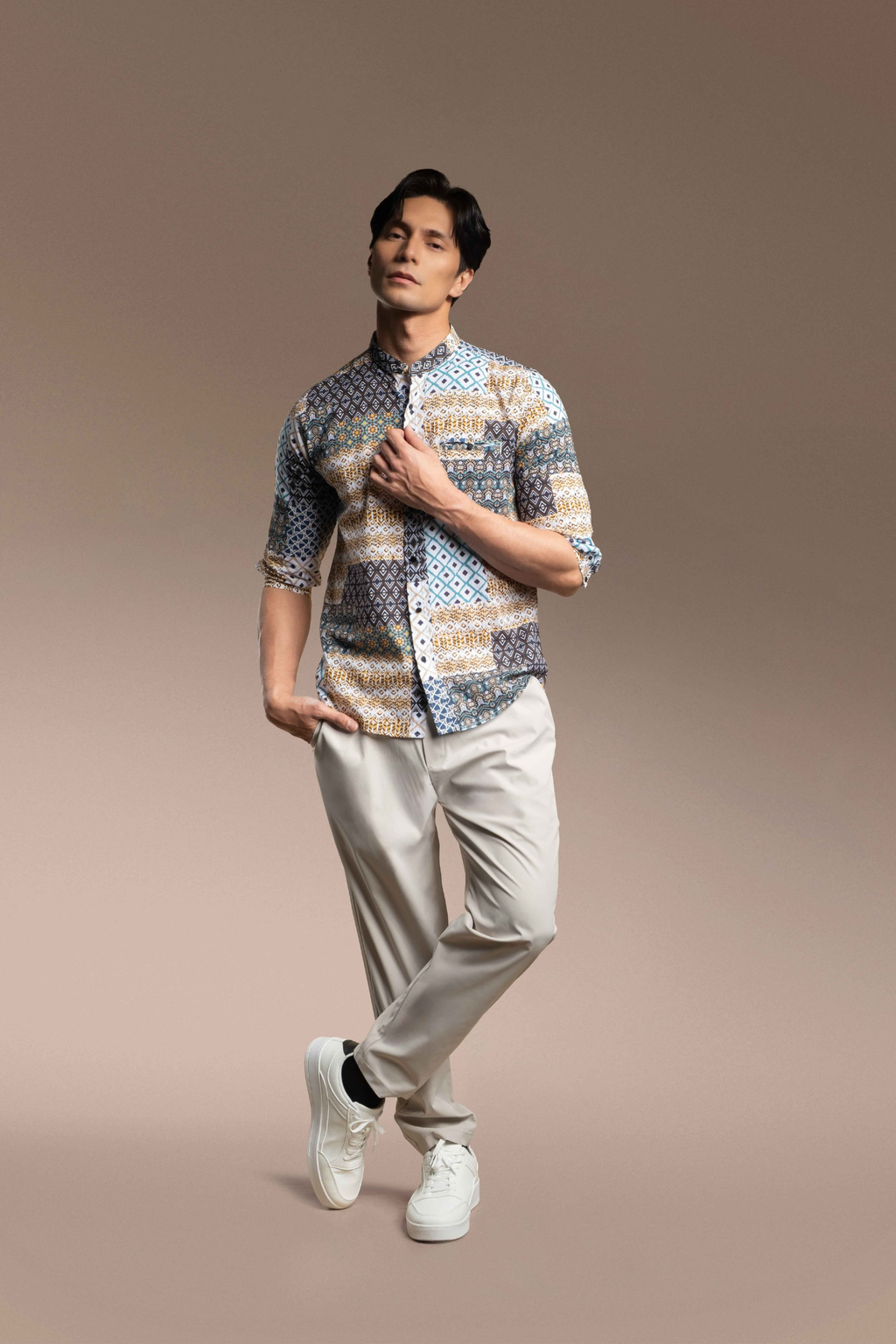 A man modeling a Onésimus Men's Casual Shirts Geometric Prints, set against a solid warm brown studio background.